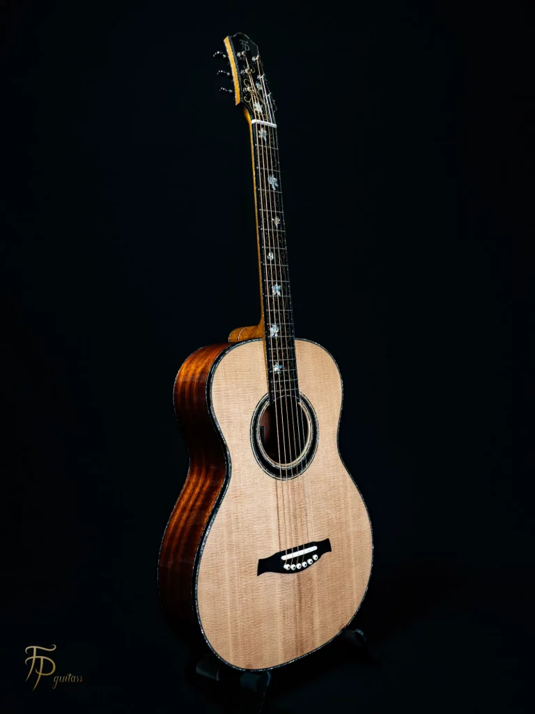 Guitare acoustique format 00 FP Guitars avec table en épicéa Sitka, dos et éclisses en satinwood rubané, manche en acajou, touche en ébène ornée d’incrustations laiton-nacre et filets en nacre — finition artisanale haut de gamme.
