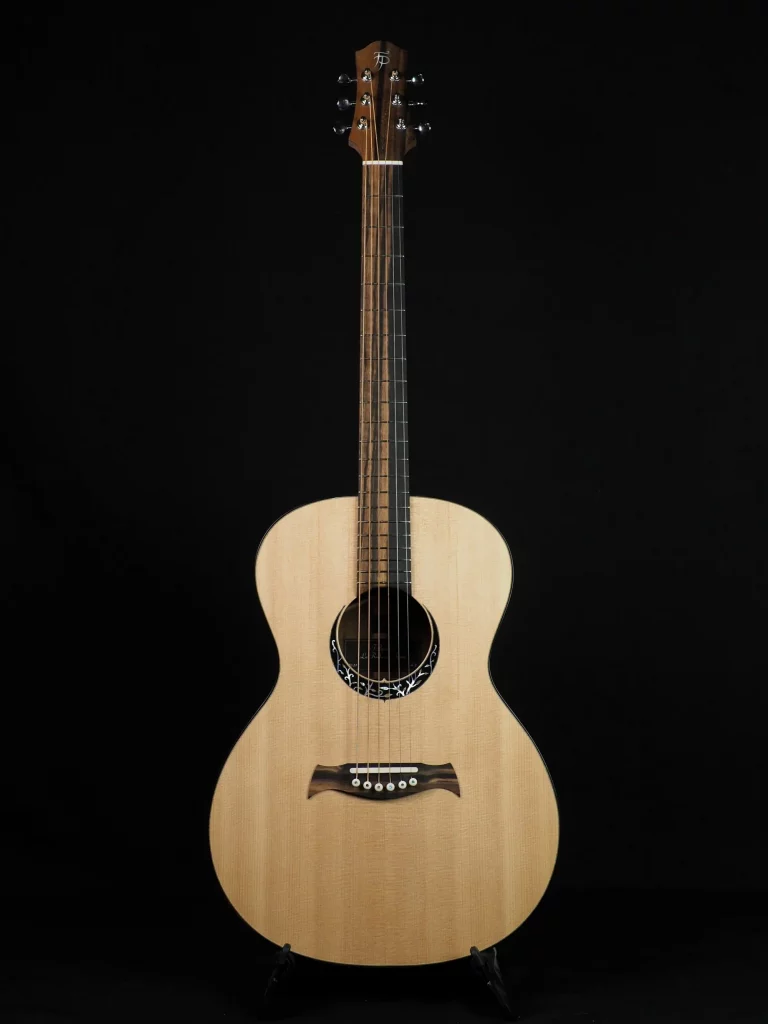 Guitare acoustique FP Guitars avec table en épicéa, dos et éclisses en ovangkol figuré et touche en ébène du Gabon, mise en valeur des contrastes naturels et du travail artisanal.