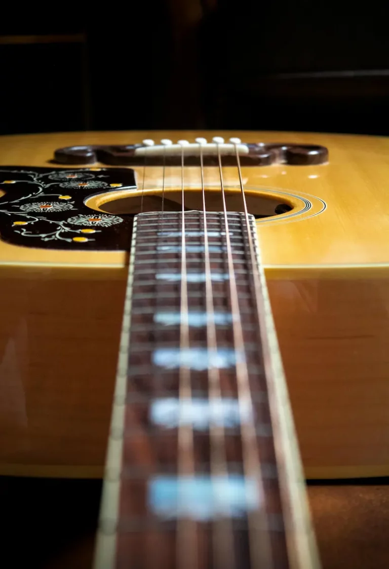 Vue rapprochée du manche et de la table d’une guitare acoustique, illustrant l’équilibre de l’instrument et la précision du travail de luthier